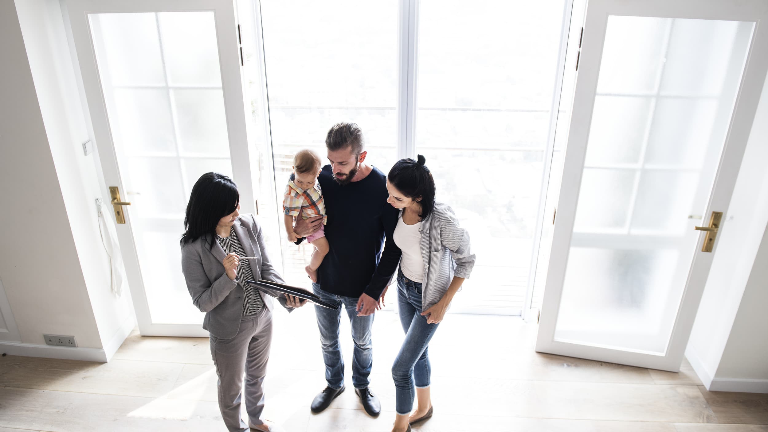 A real estate agent shows a family a bright home